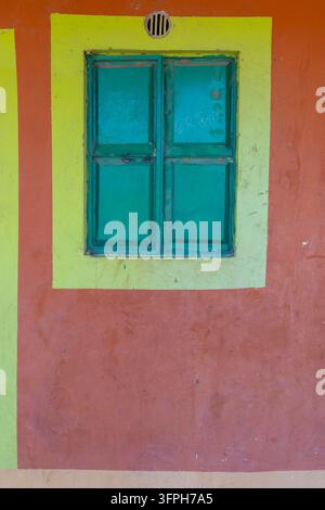 Volets métalliques verts encadrés en jaune sur un mur peint en orange au Festival culturel du lac Turkana, comté de Marsabit, Loiyangalani, Kenya Banque D'Images