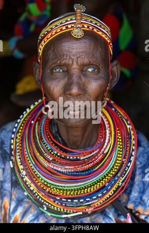 Portrait rapproché d'une femme âgée de la tribu Rendille avec un bandeau perlé et plusieurs couches de colliers perlés colorés ainsi qu'une robe bleue à motifs, M Banque D'Images