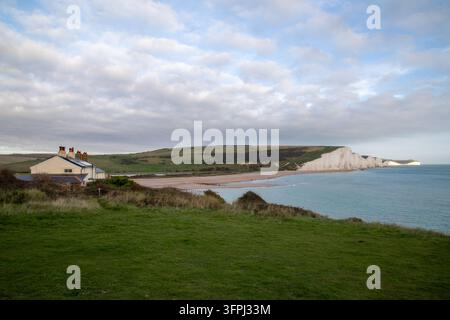 Vue panoramique des historiques cottages des gardes-côtes à Cuckmere Haven avec vue sur les falaises de craie emblématiques des Seven Sisters dans l'East Sussex Banque D'Images