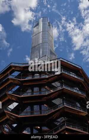 Les gradins cuivrés du Vessel s'étendent sur le premier plan tandis que 15 Hudson Yards s'élève dans un ciel manhattanen rempli de nuages à New York. Banque D'Images
