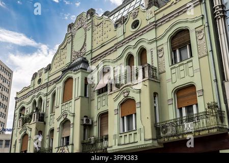 Une vue en contre-plongée d'un bâtiment Art Nouveau vert clair orné, présentant des façades complexes et des fenêtres en arc, centre-ville historique, Novi Sad, Serbie Banque D'Images