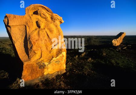 Sculpture en grès sculptée avec des figures humaines sur une colline au-dessus de l'outback près de Broken Hill, Nouvelle-Galles du Sud, à la lumière de l'heure dorée Banque D'Images