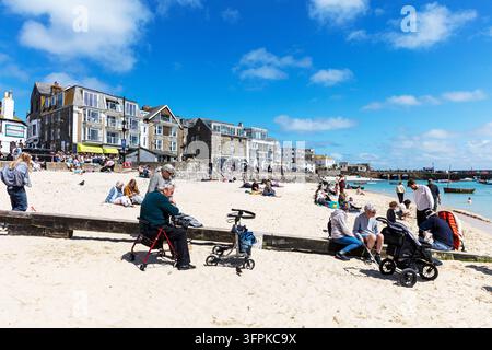 Les visiteurs se détendent sur la plage de Porthminster à côté du port de St Ives à St Ives, en Cornouailles, en Angleterre, Royaume-Uni. Les gens profitent de la plage de sable et du front de mer Banque D'Images