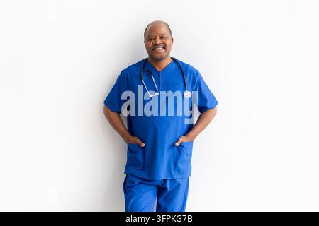 Portrait d'un professionnel de santé noir âgé et confiant portant une blouse bleue et un stéthoscope Banque D'Images