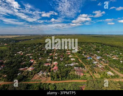 Vue aérienne de la plantation de caoutchouc de Chup entourée d'un village avec des maisons, des routes de terre et des arbres verts luxuriants à Tboung Khmum, Tboung Khmum, Cambodge. Banque D'Images