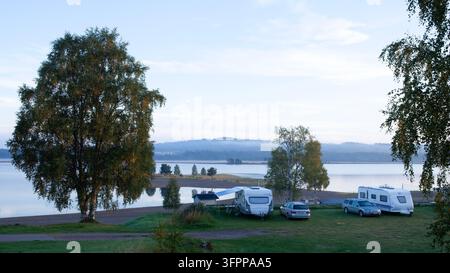 Sarna, Suède – 7 septembre 2013 : Une vue matinale des campings au bord du lac Sarna. Une belle expérience de la nature sous un soleil léger et des pelouses humides Banque D'Images