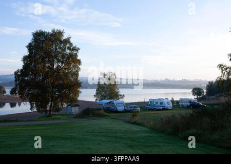 Sarna, Suède – 7 septembre 2013 : Une vue matinale des campings au bord du lac Sarna. Une belle expérience de la nature sous un soleil léger et des pelouses humides Banque D'Images