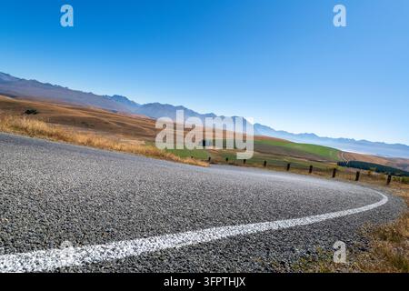 Arrière-plan routier, plaque arrière automobile, virage en épingle à cheveux pavé dans un paysage rural aspirateur avec des vues étendues Banque D'Images