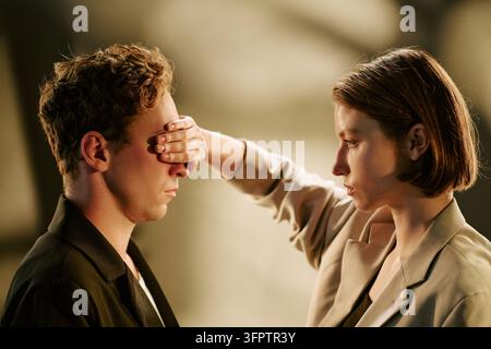 Femme couvrant les yeux d'un homme représentant un concept secret Banque D'Images