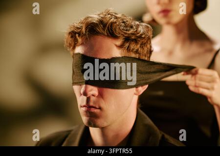 Homme les yeux bandés recevant les yeux couverts par une femme pour le concept de confiance Banque D'Images