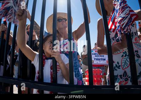 Coronado, Californie, États-Unis. 8 octobre 2026. Les membres de la famille et les supporters acclament derrière une clôture alors que le porte-avions USS Abraham Lincoln (CVN 72) retourne à la Naval Air Station North Island à Coronado, Californie, le 8 octobre 2026, après un déploiement. Un enfant observe le navire qui arrive aux côtés d'adultes agitant des décorations patriotiques, tandis qu'une pancarte en arrière-plan indique ''Bienvenue à la maison Tristin. (Credit Image: © Logan Graham/ZUMA Press Wire) UTILISATION ÉDITORIALE UNIQUEMENT ! Pas pour un USAGE COMMERCIAL ! Banque D'Images