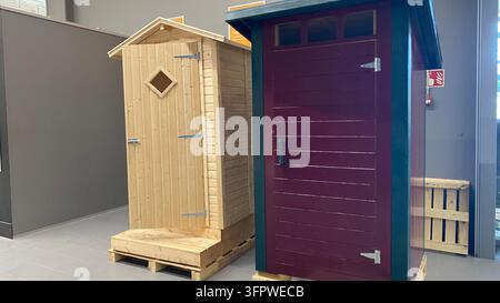 Deux cabanes de toilette d'extérieur en bois naturel et rouge foncé exposées dans un magasin de bricolage Banque D'Images
