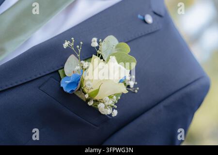 Bouquet de boutonnière attaché à une veste de costume, en extérieur peut-être lors d'un événement ou d'une cérémonie, avec boutonnière, veste de costume, bouton, d'un plan rapproché depuis le Banque D'Images