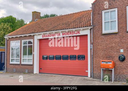 Moerdijk, Pays-Bas – 4 juin 2026 : Bâtiment de caserne de pompiers avec une porte de garage rouge et une boîte aux lettres PostNL sur un mur de briques, services d’urgence locaux et infrastructures publiques dans une ville néerlandaise. Banque D'Images