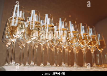 Range élégante de verres à vin blanc préparés pour une réception de traiteur, composition horizontale Banque D'Images