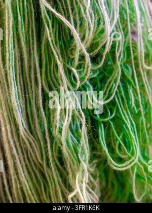 Près-plan détaillé de fond abstrait composé de fibres de laine vert vif enchevêtrées et suspendues avec une texture douce. Banque D'Images