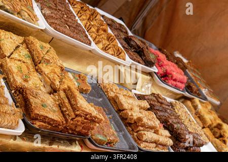 Variété de pâtisseries baklava traditionnelles du Moyen-Orient exposées sur un étal de marché Banque D'Images