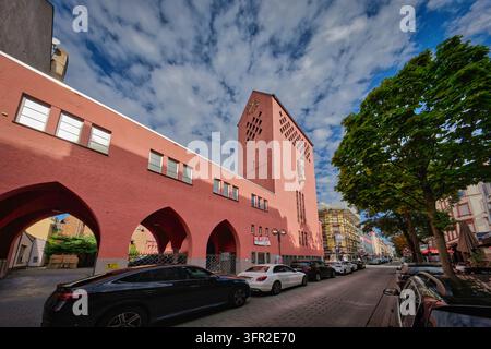 Francfort, Allemagne, 04 octobre 2026 : Façade rose et clocher de l'historique église Saint-Josef à Francfort-Bornheim avec colonnades cintrées et rue Banque D'Images