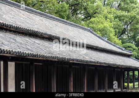 Vue détaillée d'un long toit en tuiles et de colonnes en bois sur un bâtiment historique du palais impérial de Tokyo, Japon Banque D'Images