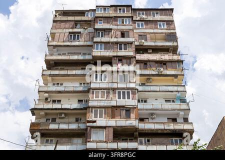 Vue en contre-plongée d'une haute tour d'habitation de l'ère soviétique avec balcons contre un ciel nuageux, Erevan, Erevan, Arménie Banque D'Images