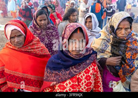 Close-up de femmes sérieuses portant des châles rouges et floraux avec bindis et anneaux au nez dans une foule à la Maha Kumbh Mela, Uttar Pradesh, Prayagraj, Inde Banque D'Images