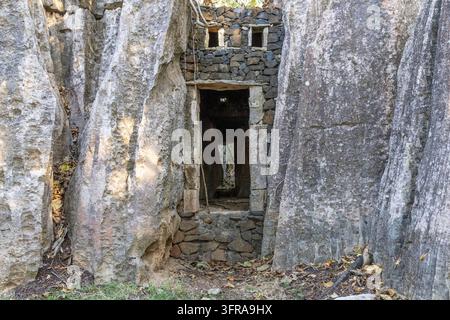Ancienne ruine en pierre avec une porte et des ouvertures de fenêtres se dressant entre des pitons de calcaire érodés imposants au Petit Tsingy, Melaky, Petit Tsingy, Mada Banque D'Images
