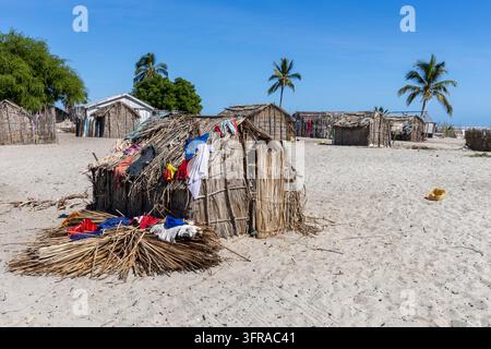 Cabane de village de pêcheurs au toit de chaume avec des vêtements colorés séchant sur son toit sous un ciel bleu, Menabe, Belo sur Mer, Madagascar Banque D'Images