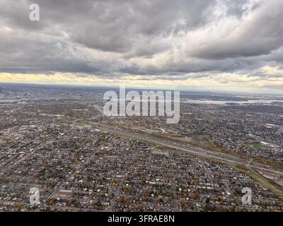 Vue aérienne époustouflante de Longueuil au Québec, Canada, mettant en valeur le paysage urbain étendu et les quartiers depuis le ciel sous un ciel nuageux dramatique Banque D'Images