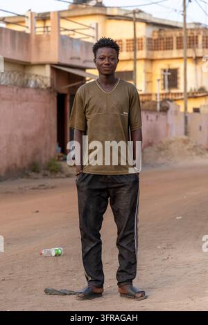 Portrait d'un jeune homme debout sur une rue poussiéreuse, Région Maritime, Lomé, Togo Banque D'Images