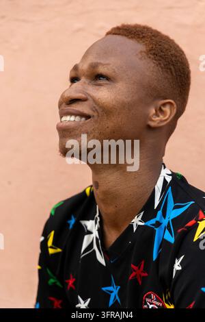 Portrait souriant d'un jeune homme regardant vers le haut, Région Maritime, Aneho, Togo Banque D'Images