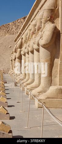 Statues en pierre de l'Égypte antique alignées le long d'une colonnade au Temple Funéraire de Hatchepsout à Deir el-Bahari, près de Louxor, Égypte. Banque D'Images