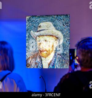 Bratislava, Slovaquie - 3 octobre 2026 : Des visiteurs photographient un écran numérique interactif du « Self-Portrait avec chapeau de feutre gris » de Vincent van Gogh dans un Banque D'Images