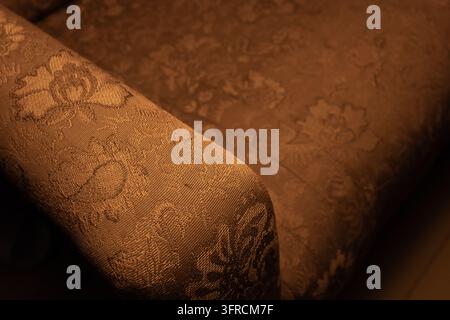Texture de tissu d'ameublement vintage à motif floral marron sur des meubles anciens, gros plan Banque D'Images
