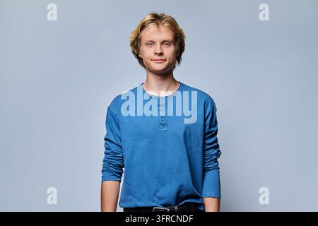 Jeune homme blond souriant regardant la caméra dans un portrait de studio décontracté Banque D'Images