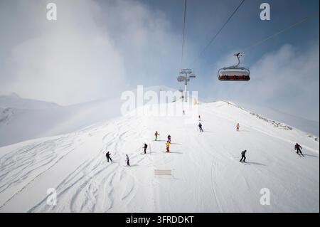 Panorama de la station de ski, piste, personnes sur le téléphérique, skieurs et snowboardeurs sur la piste avec une neige blanche. Journée de vacances ensoleillée, vue aérienne Banque D'Images
