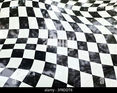 Motif à carreaux déformé avec une surface ondulée et déformée créant une illusion d'optique abstraite en noir et blanc Banque D'Images