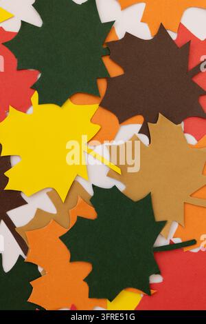 Ensemble de feuilles en papier dans des tons automnaux, regroupées en gros plan sur un fond blanc, concept de créativité, de bricolage et de décoration saisonnière Banque D'Images