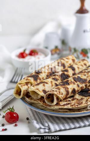 Lefse norvégien traditionnel – crêpes fines de pommes de terre avec sauce à la crème fraîche et tomates cerises caramélisées, mise au point sélective Banque D'Images