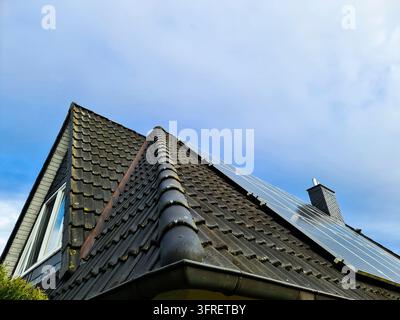 Toit de la maison avec des panneaux solaires convertissant la lumière du soleil en électricité propre, mettant en valeur l'énergie renouvelable durable et rentable pour les résidants modernes Banque D'Images