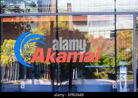 Santa Clara, Californie, États-Unis - 6 septembre 2026 : Logo d'Akamai Technologies sur la façade vitrée d'un immeuble de bureaux reflétant des arbres Banque D'Images