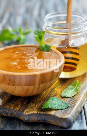 Miel de fleurs dans un bol et un pot en verre avec du miel de tilleul, mise au point sélective Banque D'Images