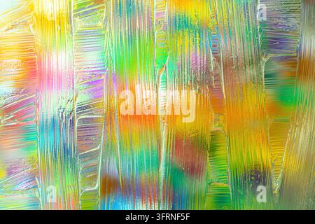 Art abstraite vibrante originale présentant des coups de peinture irisés superposés en jaune, vert, rose, bleu et or, créant un fond texturé lumineux Banque D'Images