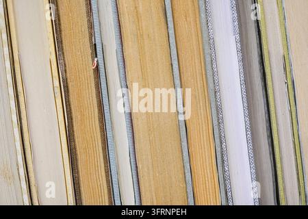 Vieux livres disposés dans une rangée affichée dans la librairie antique, détail de gros plan sur les pages colorées jaunes de côté Banque D'Images