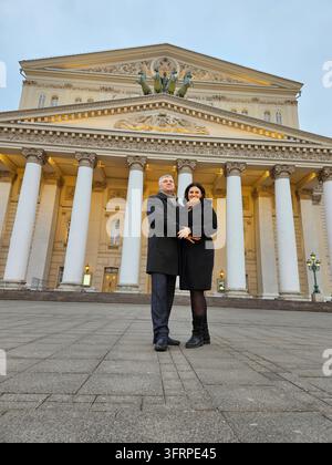 Un homme et une femme se tiennent devant un bâtiment, le grand théâtre Bolshoy à Moscou, en Russie. La femme porte un manteau noir Banque D'Images