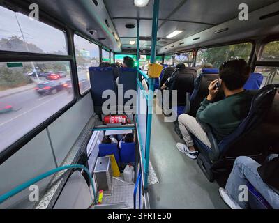 ISTANBUL - 27 SEPT 2025 : Le bus est plein de passagers, dont certains parlent au téléphone portable. Le bus circule dans une rue animée avec des voitures et des camions en arrière-plan Banque D'Images