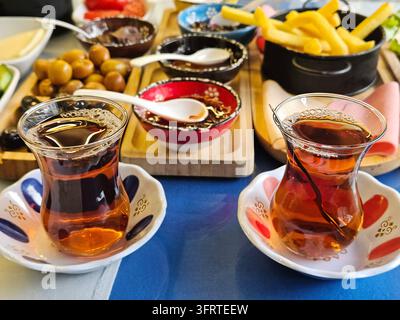 Table avec une variété de nourriture et de boissons, dont deux tasses de thé. La table est dressée pour un repas, et les tasses de thé sont placées au centre de la table Banque D'Images
