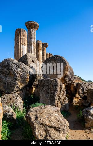 Vue verticale à travers les tambours de colonnes tombés et les blocs érodés vers les colonnes doriques debout du Temple d'Héraclès à Agrigente. Banque D'Images