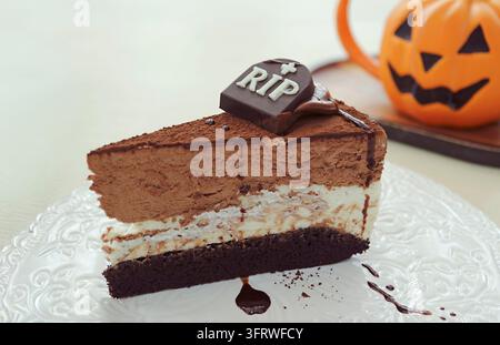 Délicieux gâteau au chocolat triple couche d'Halloween garni d'une pierre tombale en chocolat effrayante avec inscription RIP Banque D'Images