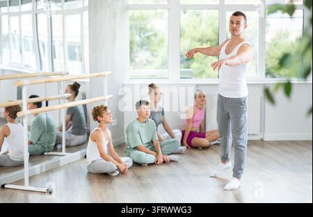 Danseur professeur masculin exécutant un pirouette devant la classe Banque D'Images