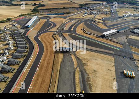 Une vue aérienne du calme circuit de Silverstone, entouré de champs d'herbe sèche par un après-midi d'été calme et lumineux sans activité de course. Banque D'Images